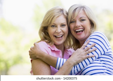 Two Women Outdoors Hugging And Smiling