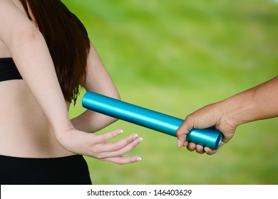 Two Women Passing A Baton In Relay Race