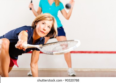 Two Women Playing Squash As Racket Sport In Gym