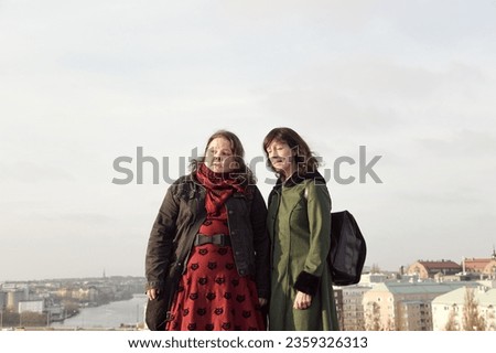 Similar – Foto Bild fröhliche Zwillingsschwestern stehen lachend vor einer Mauer