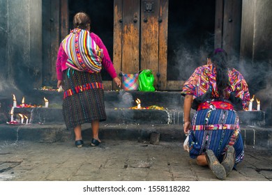 Two women are praying their knees in the cathedral Santo Tomás Chichicastenango 