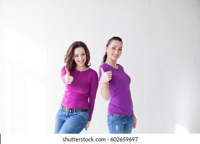 two women in purple clothes show fingers
