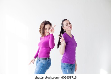two women in purple clothes show fingers
