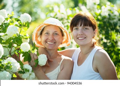 Two Women In Roseum Plant At Garden