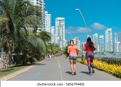 Two Women Running Backwards Through The Park