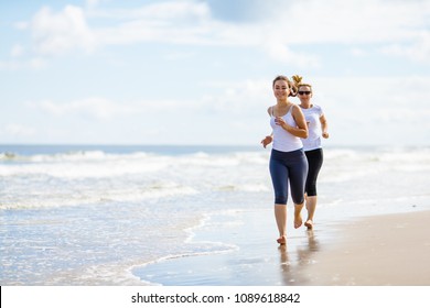 Two Women Running On Beach 