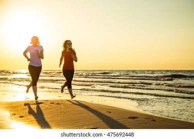 Two Women Running On Beach 