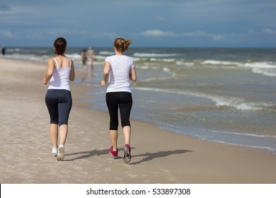 Two Women Running On Beach 