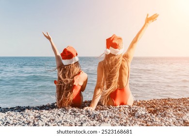 Two Women in Santa Hats on a Beach - Powered by Shutterstock