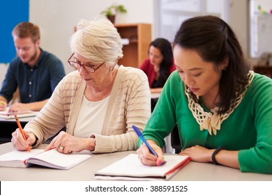 Two Women Sharing A Desk At An Adult Education Class