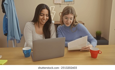 Two women sharing documents and using a laptop together at home in a casual setting - Powered by Shutterstock