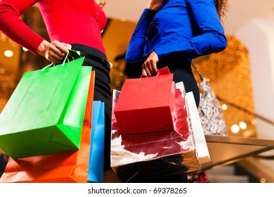 Two Women In A Shopping Mall With Colorful Bags Simply Having Fun