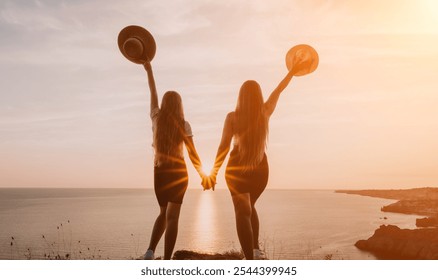 Two Women Silhouetted Against a Sunset on a Clifftop - Powered by Shutterstock