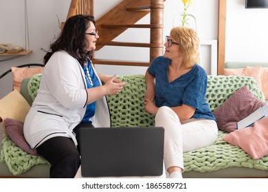 Two women sit on the sofa and talk. They discuss various business topics.