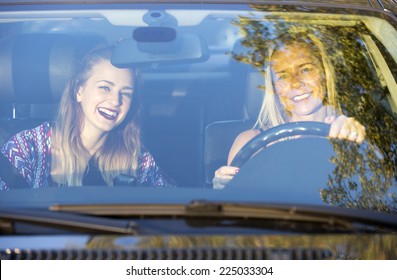 Two Women Sitting In A Car And Laugh