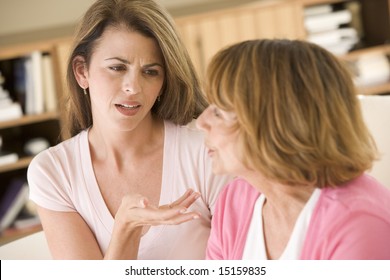 Two Women Sitting In Living Room Arguing