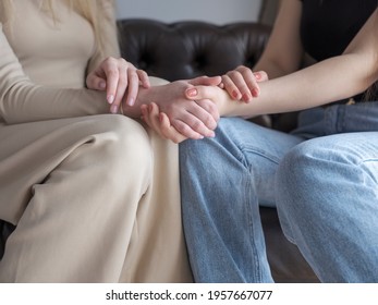 Two Women Are Sitting On The Couch. Holding Hands. The Concept Of Confidential Conversation Between Women, Girlfriends, Mom And Daughter.