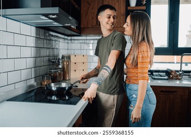 Two women smiling and gazing at each other while cooking together in a modern kitchen, fostering a warm and intimate atmosphere filled with love and connection - Powered by Shutterstock