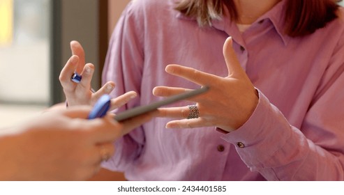 Two Women Solving Business Tasks with Tablets in Casual Cafe Atmosphere. Hands close-up gesturing focusing on communication, body language, or expression. Conveying messages effectively, lifestyle. - Powered by Shutterstock