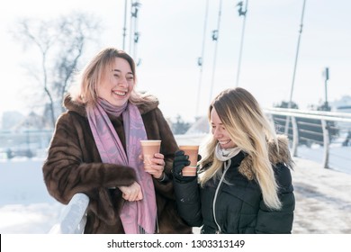 Two Women Standing On The Bridge Laughing And Drinking Coffee With Foam On Their Lips