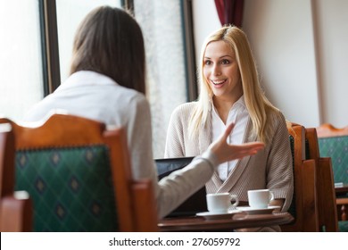 Two Women Talking In A Cafe