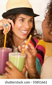 Two Women Are Talking And Enjoying Smoothies Together.  Vertical Shot.