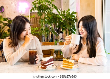 Two Women Talking Over Coffee And Dessert Cake In A Coffee Shop