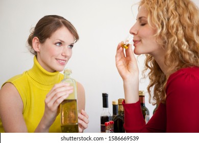 Two women tasting a sample of olive oil - Powered by Shutterstock