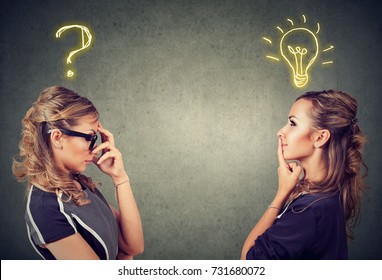 Two women thinking one has a question another solution with light bulb above head isolated on gray background. - Shutterstock ID 731680072