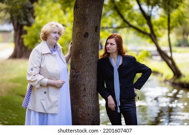 Two women together - blonde in light and redhead in dark clothes chatting on a sunny day in the park under a tree.
Cosplay - female version of Angel and Demon (Good Omens) - Shutterstock ID 2201607407