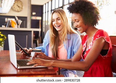 Two women using computers in a coffee shop - Powered by Shutterstock