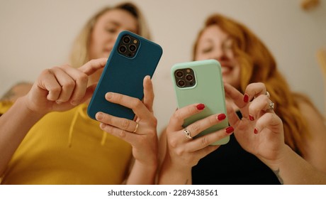 Two women using smartphones standing at home - Powered by Shutterstock