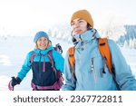 Two women walk in the snow, winter trekking, two people in the mountains in winter, hiking equipment