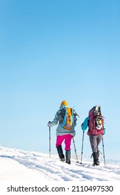 Two Women Walk In Snowshoes In The Snow, Winter Trekking, Two People In The Mountains In Winter, Hiking Equipment