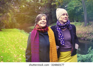 Two Women Walking In The Park In Fall