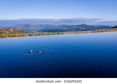 Two Women Wild Swimming In A Lake Outdoors On A Summer Morning In The Keepers Pond Brecon Beacons Wales UK