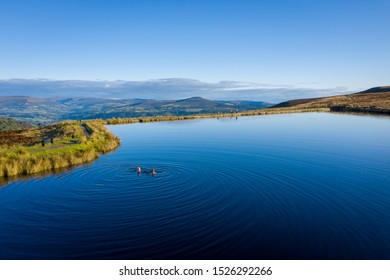 Two Women Wild Swimming In A Lake Outdoors On A Summer Morning In The Keepers Pond Brecon Beacons Wales UK