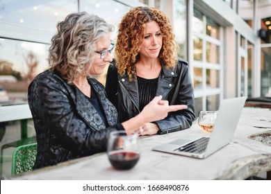 Two Women Working Together Outside With A Laptop Computer