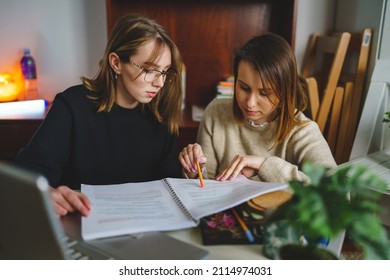 Two Women Young Caucasian Female Student Sitting At Home With Her Mentor Teacher Looking To The Notebook Explaining Lesson Study Preparing For Exam Learning Education Concept Real People Copy Space