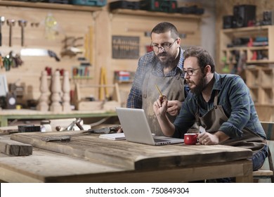 Two wood designer working with laptop in workshop. - Powered by Shutterstock