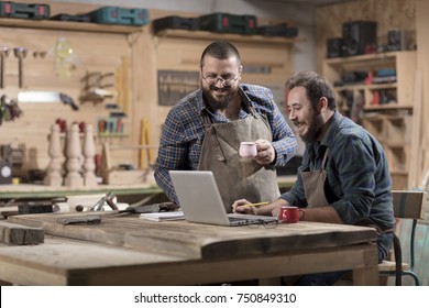 Two wood designer working with laptop in workshop. - Powered by Shutterstock