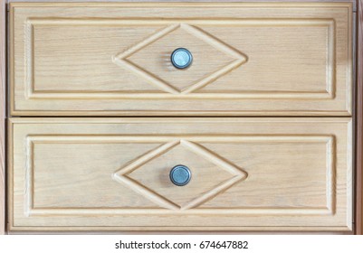 Two wooden drawers with metal knobs as seen from the front