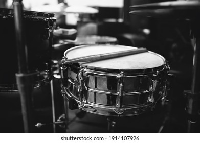 Two Wooden Drumsticks Are On The Drum Kit Near The Cymbals. The Concept Of A Musician, Jazz Band And Rock Band. Black And White Photography.