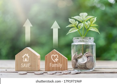 Two Wooden Houses And A Jar, A Tree And Money Coin Inside Money-saving Ideas To Buy A Better Home, Better Quality Of Life. Growing Trees And Saving Money.