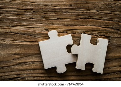 two wooden jigsaw puzzle couple of pieces texture pattern on wood texture background of trunk. empty copy space for inscription or objects. business concept