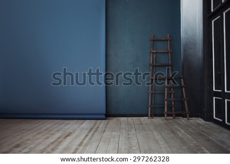 Two Wooden ladder, near dark blue wall, perspective    