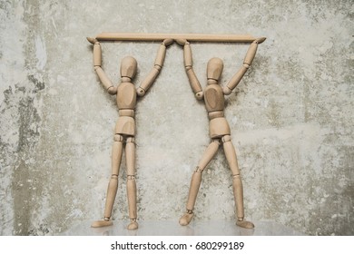 two Wooden Mannequin figure holding plank line on concrete wall background. - Powered by Shutterstock