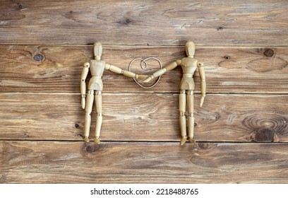 Two Wooden Mannequins As Lovers With Their Hands Tied By A Heart