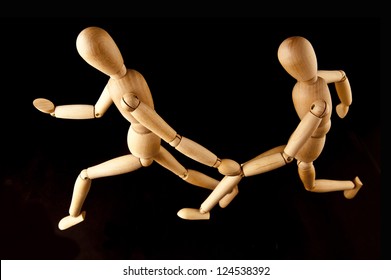 Two wooden mannequins running relay at a greater distance and the process of transfer of the baton. top view - Powered by Shutterstock