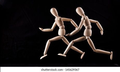 Two wooden mannequins running relay at a greater distance and the process of transfer of the baton on black background  Copy Space for insription  - Powered by Shutterstock